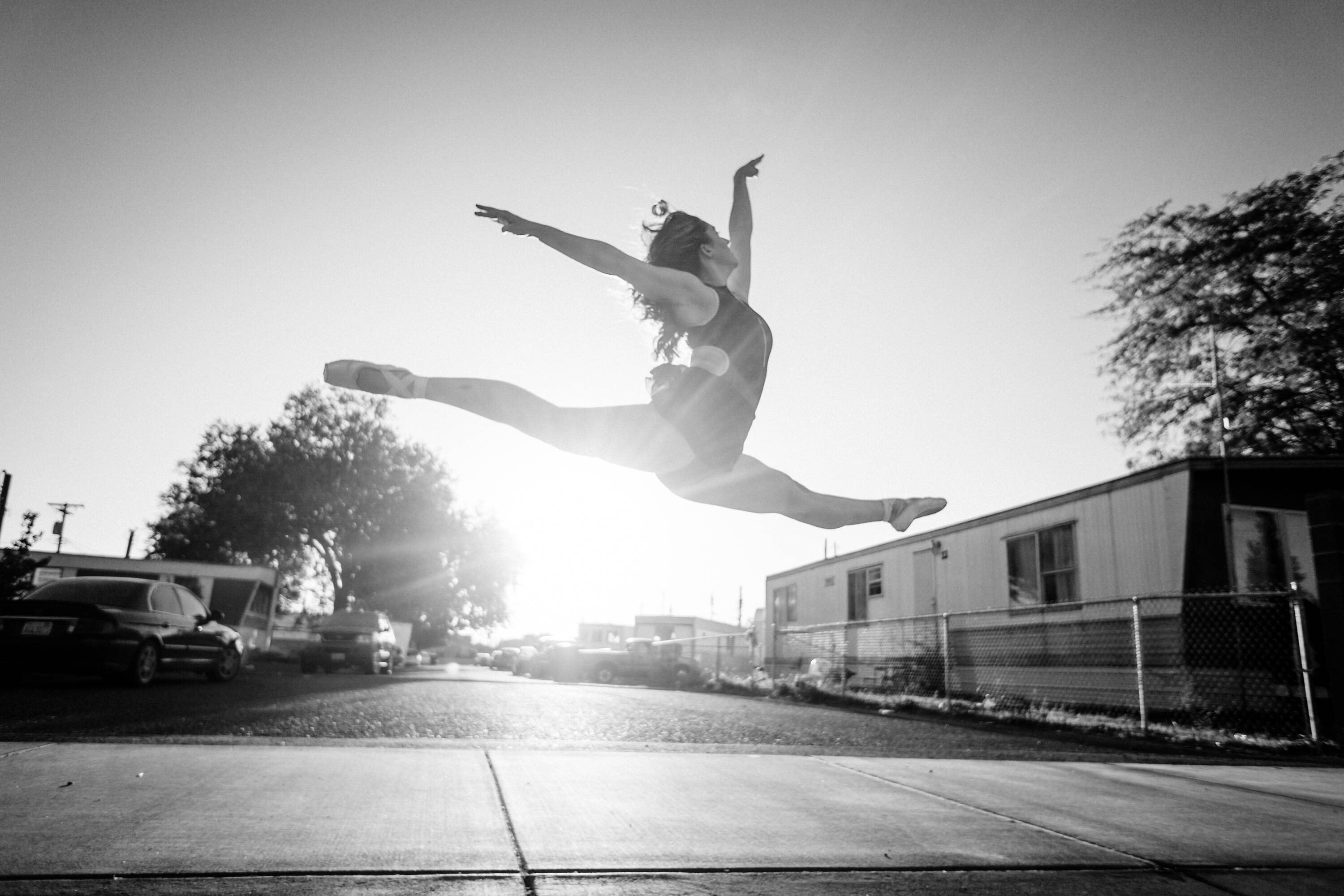 a ballet dancer in a pose - juxtaposition with trailer park in the backgroud