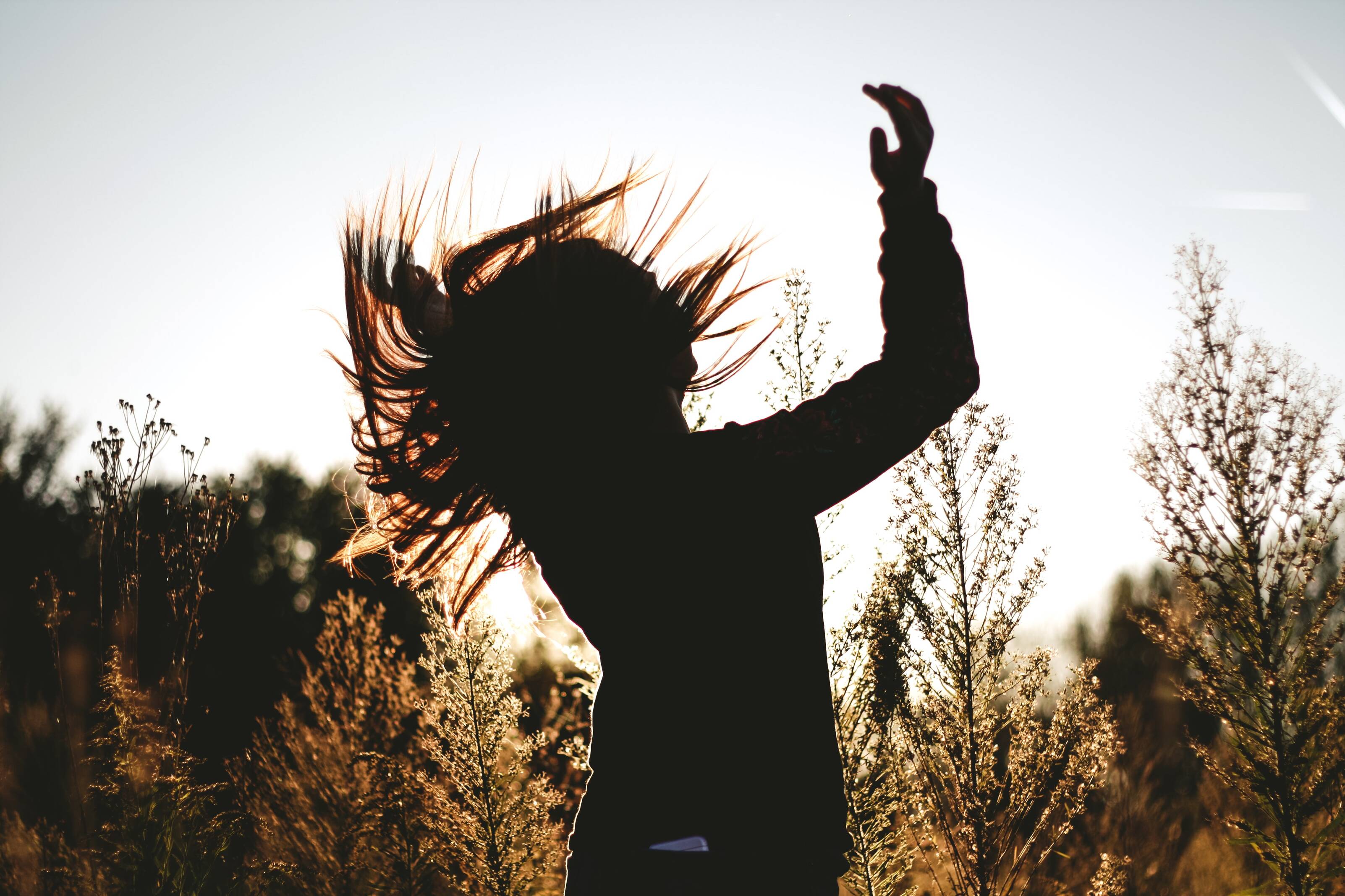 silhouette of a woman jumping - nature background